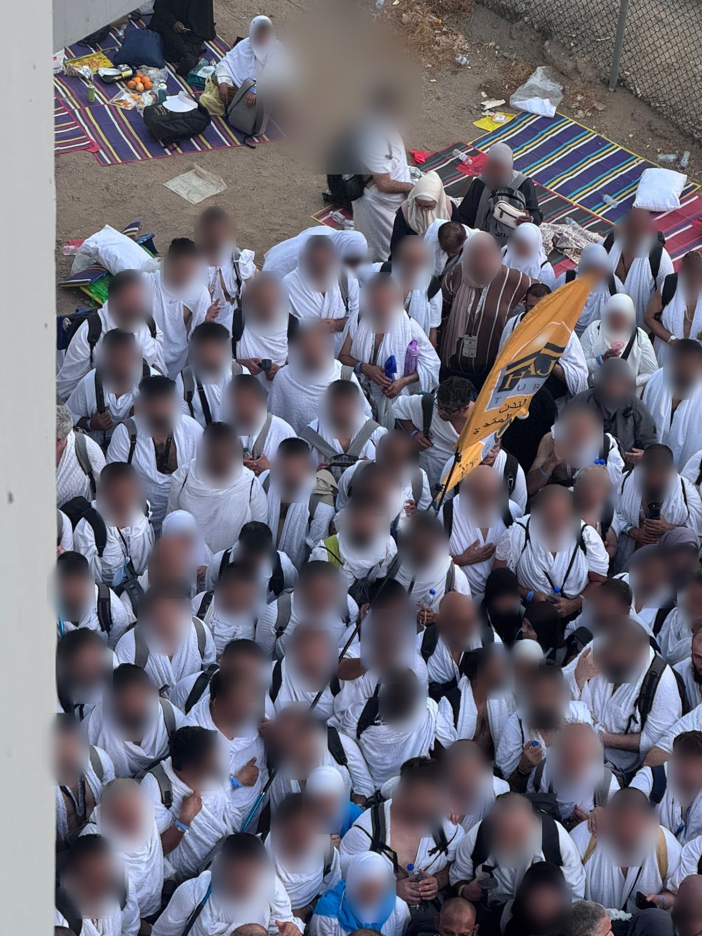 Our pilgrims in ihram following the Haj Tours flag